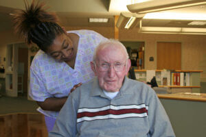 A caregiver with wheelchair bound long-term-care-patient. Caregivers are valuable witnesses in Nursing home abuse cases.